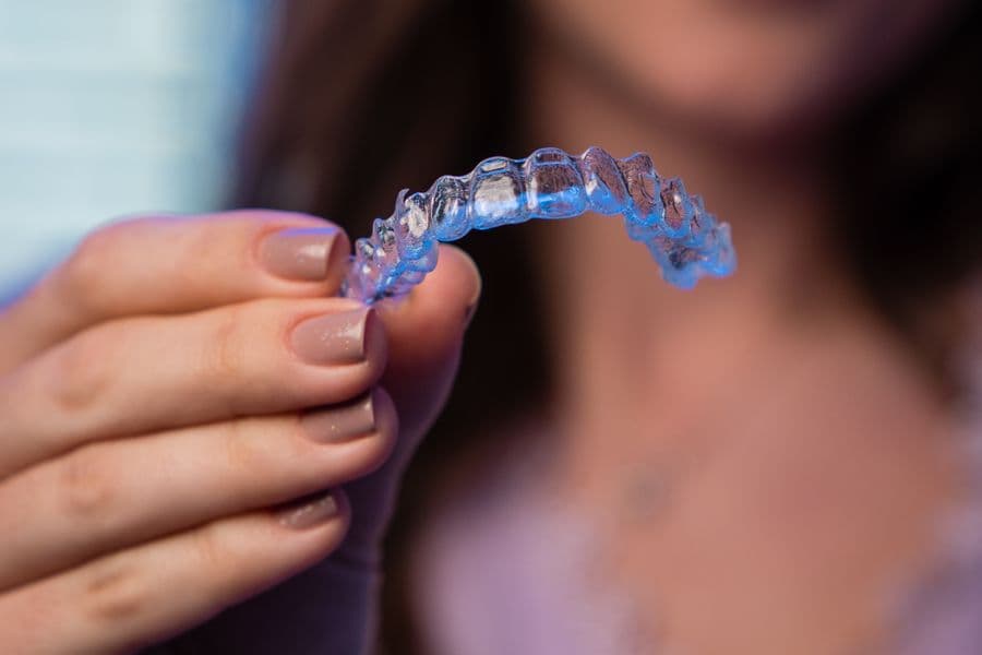 A person holding a clear dental aligner